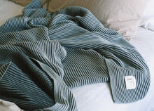 Load image into Gallery viewer, Ribbed cotton knit throw blanket in mint blue and dark green draped casually on a bed, with Lumi Living label visible