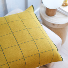 Load image into Gallery viewer, Mustard yellow cotton knit pillow cover with green lines windowpane grid pattern on white accent chair next to wooden side table
