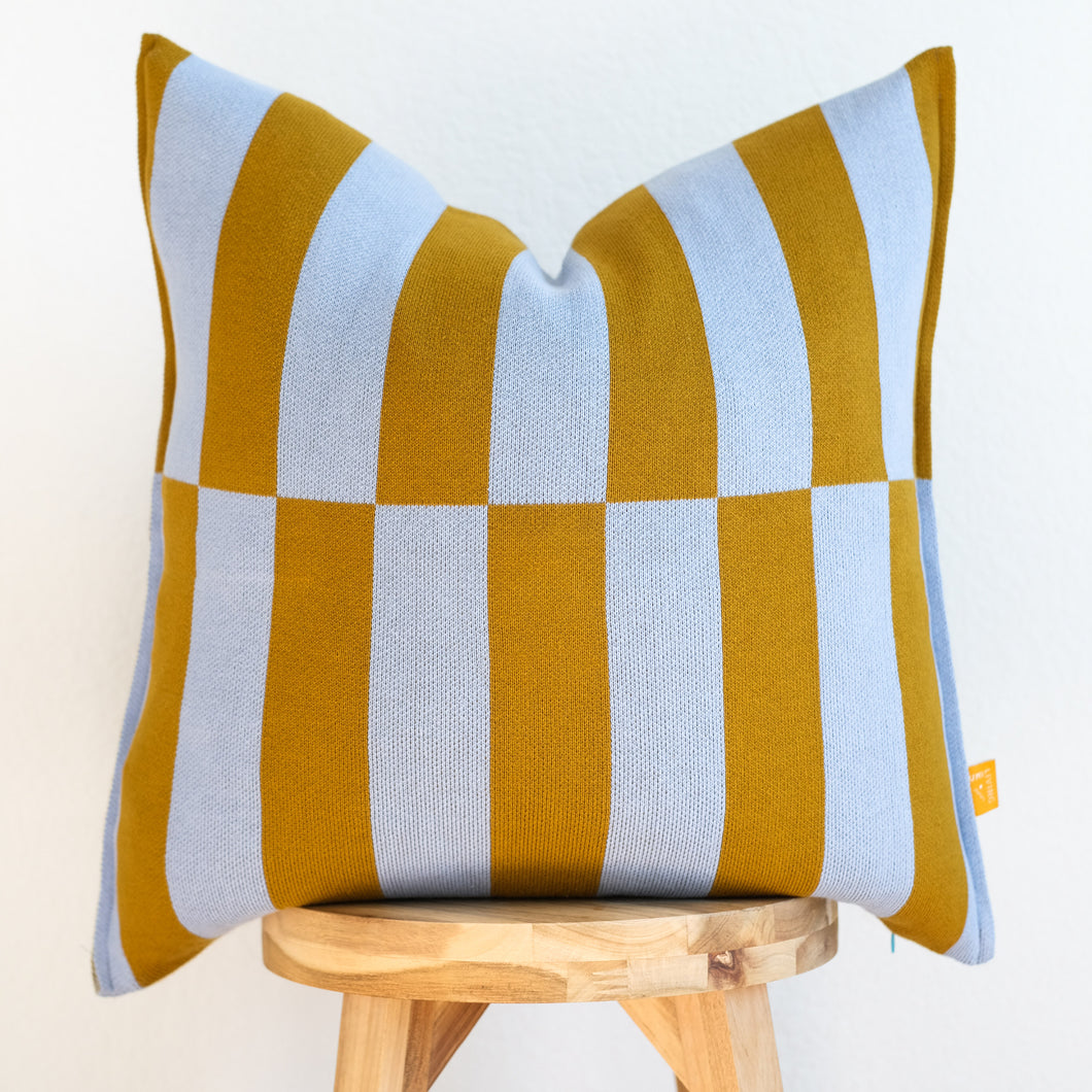 bold striped cotton pillow cover in mustard and sky blue on wooden stool