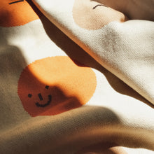 Load image into Gallery viewer, Detail of soft cotton knit fabric with expressive cartoon face and earth-tone color blocking, part of the My Feelings kids blanket design
