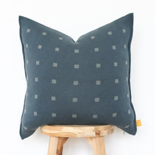 Load image into Gallery viewer, Deep teal pillow cover with modern square motif, displayed on a stool.
